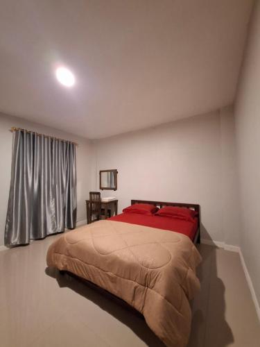 a bedroom with a bed with red sheets and a window at Waceno Umma in Ruteng