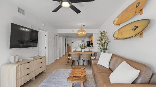 a living room with a couch and a surfboard on the wall at August Beach Escape Special Rates Available! in St. Pete Beach
