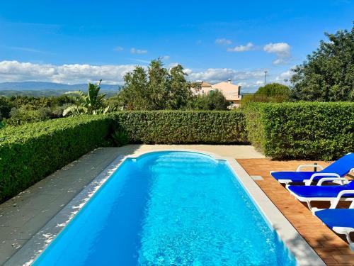 a swimming pool with blue chairs and a swimming pool at Casa da Eira - Private Villa - pool - Free wi-fi - Air Con in Silves