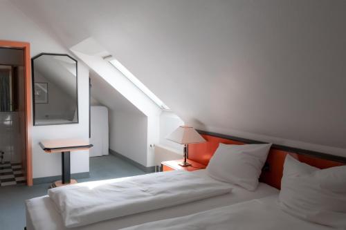 a bedroom with a white bed and a mirror at Hotel Brößler in Stockstadt am Main