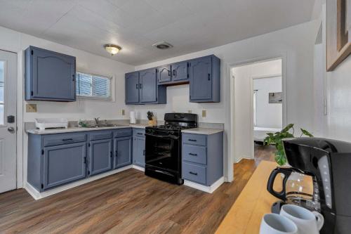 a kitchen with blue cabinets and a black stove at Housepitality - The Southside Ranch in Columbus