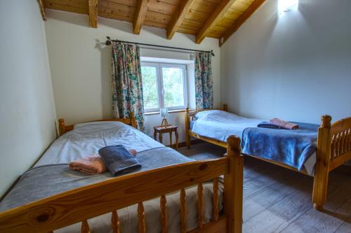a bedroom with two beds and a window at Gîtes de Peyrounou in Lacapelle-Biron