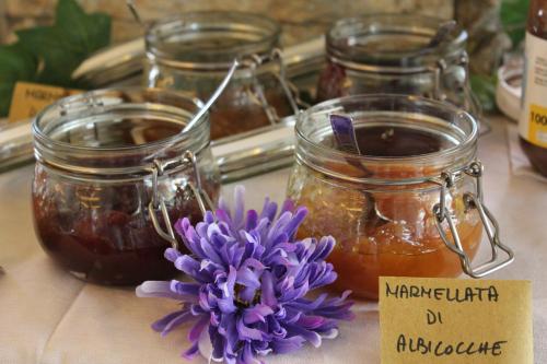 a table with jars of honey and a purple flower at Hotel Sogno in Cesenatico