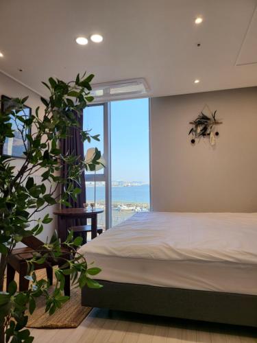 a bedroom with a bed and a large window at Ocean View Hotel near Incheon Airport in Chagyak-to