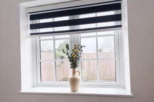 a window with a vase with flowers in it at Spacious En-suite Private Double Bedroom in Oxford