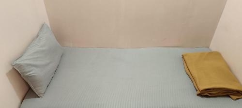 a white bed with a pillow and a blanket on it at Ekanaa Cottages in Chennai