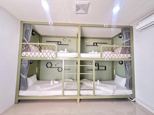 a room with three bunk beds in it at Beach Yard Hostel in Ban Nua