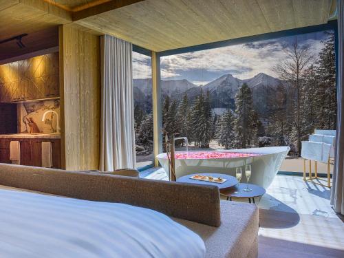 a bedroom with a bed and a tub and a view at Luxury Chalet Strachan - Jacuzzi and Sauna in Ždiar