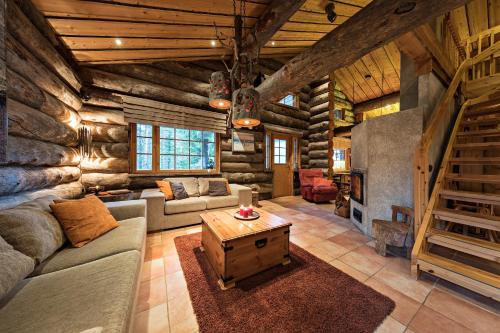 a living room with a couch and a fireplace in a log cabin at UnelmaVeska in Ruka