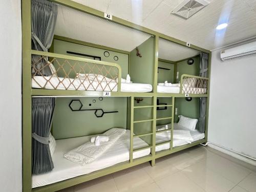 a room with three bunk beds in a room at Beach Yard Hostel in Ban Nua