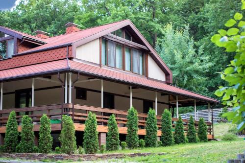 a house with a row of trees in front of it at Penates Aparthotel in Koropovo