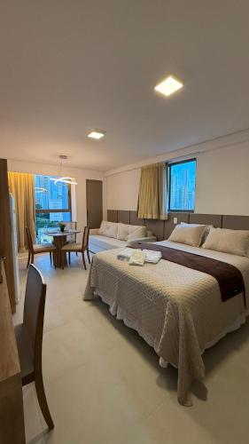 a large bedroom with two beds and a dining room at Flat Luxo em Boa Viagem - 5min do Aeroporto - perto da praia - Wi-Fi 500mb - check-in 24h in Recife
