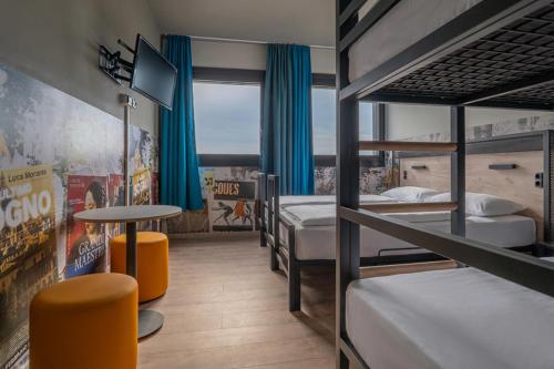 a room with two bunk beds and a table at a&o Hostel Milano Ca Granda in Milan
