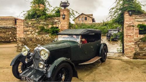an old green car parked in front of a building at Hostería Camino in Luyego de Somoza