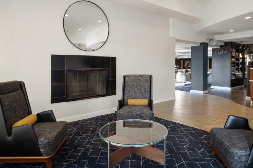 a lobby with two chairs and a glass table at Courtyard Hartford Cromwell in Cromwell