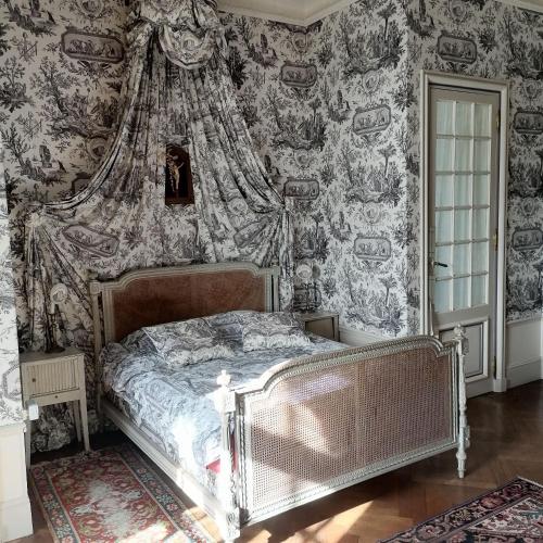 a bedroom with a bed in a room with wallpaper at Manoir de Villers in Saint-Pierre-de-Manneville