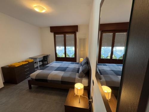 a bedroom with a bed and a desk and a mirror at La Gare Apartments - Zerbion in Châtillon