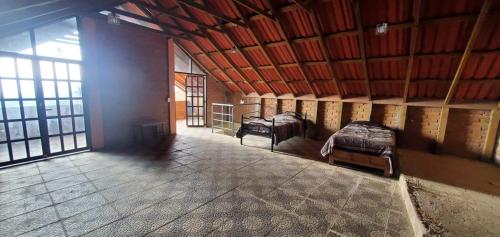 a room with two beds in a building with windows at Zirahuén 6 personas in Zirahuén