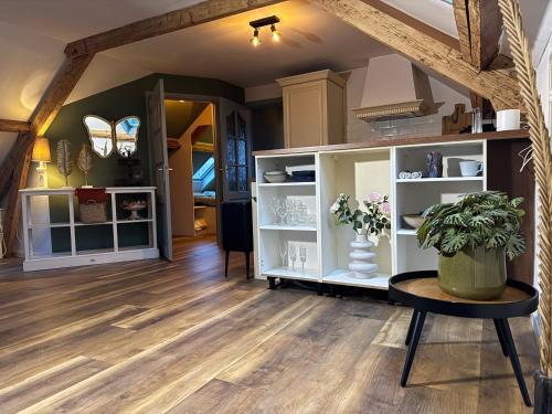 a living room with wooden floors and a table at Bij Parels landelijk overnachten in het groen in Velserbroek