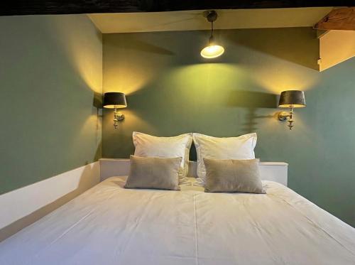 a white bed with two pillows in a room at Bij Parels landelijk overnachten in het groen in Velserbroek