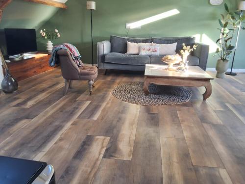 a living room with a couch and a coffee table at Bij Parels landelijk overnachten in het groen in Velserbroek
