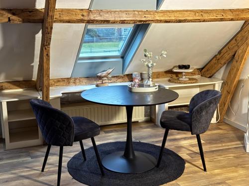 a table and chairs in a room with a window at Bij Parels landelijk overnachten in het groen in Velserbroek
