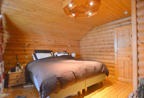 a bedroom with a bed in a log cabin at le chalet in Planay