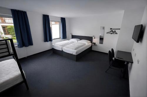 ein Schlafzimmer mit zwei Betten, einem Stuhl und einem Fenster in der Unterkunft Zzzimple in Pillig