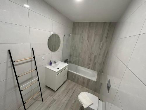 a white bathroom with a sink and a bath tub at CASA ANALUCIA in Faro