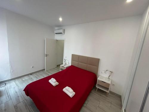 a bedroom with a red bed with two towels on it at CASA ANALUCIA in Faro