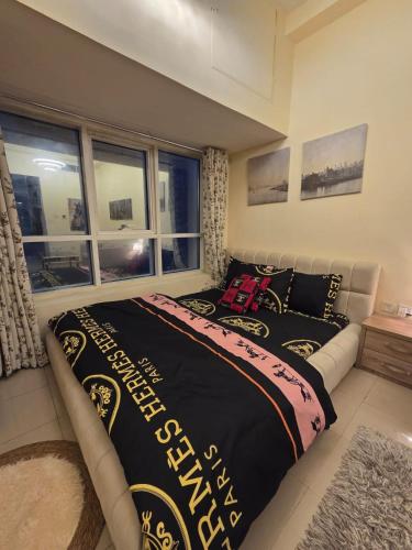 a bedroom with a bed with a black and white blanket at Apartment in ajman in Ajman 