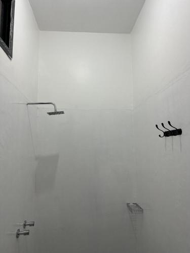 a white wall with three black sculptures on it at Bahari guesthouse in Nungwi