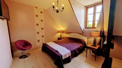 a bedroom with a bed and a red chair at Les tuilières in Masléon