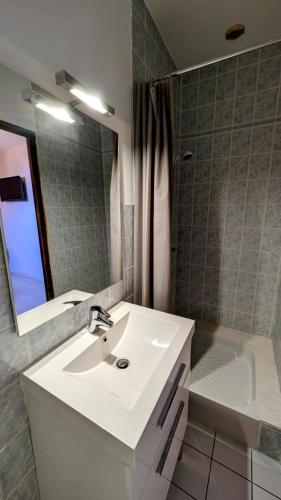 a bathroom with a sink and a mirror and a tub at Les tuilières in Masléon