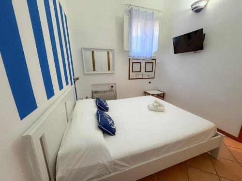 a small bedroom with a white bed and a television at Milion's House Apartments in Minori