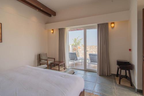 a bedroom with a bed and a balcony with chairs at Vanthra Vilas, Jawai - Luxury Villas with Private Pools in Bijāpur