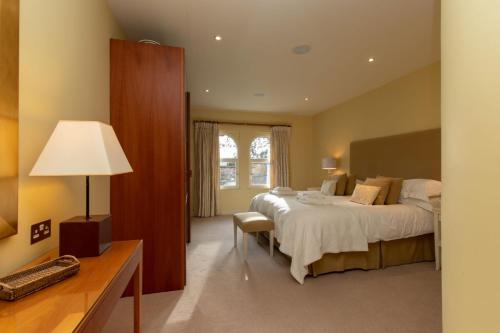 a bedroom with a bed and a desk with a lamp at Underscar - Luxury 1 Bed Apartment in Applethwaite