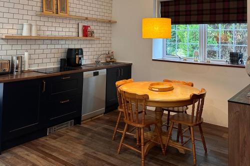 a kitchen with a wooden table and a table and chairs at Pets - Garden - Parking - Sleeps up to 4 - Hiking in Banchory