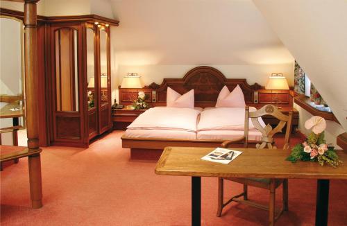 a bedroom with a bed with pink pillows on it at CityHotel Dormagen in Dormagen
