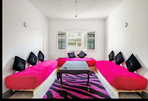a living room with a red couch and a table at Villa à harhora in Temara