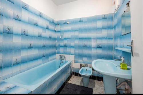 a blue tiled bathroom with a tub and a sink at Villa à harhora in Temara
