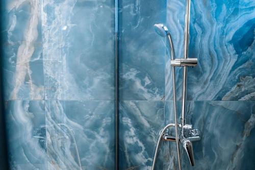 a shower in a bathroom with a blue wall at ILIADA Boutique Rooms in Faliraki
