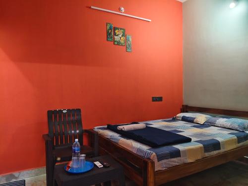 a small bedroom with a bed and a chair at Ocean Wind Homestay in Pondicherry