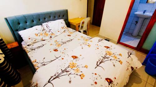 a bedroom with a bed with flowers on it at Park View Perch Guest house with Balcony near Downtown in Kigali