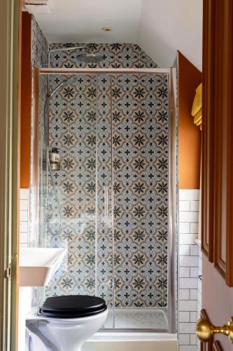a bathroom with a toilet and a tiled wall at Bull Inn in Reading