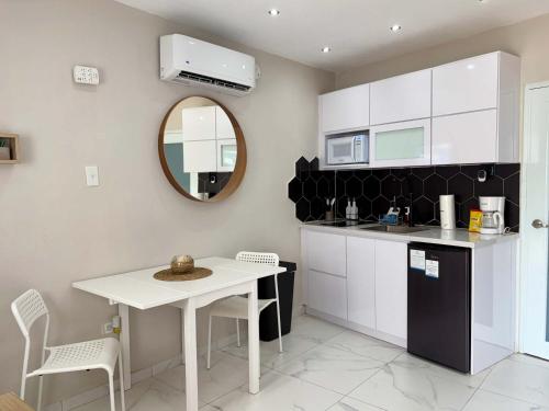 Una cocina con una mesa blanca y un espejo. en Salitre Studio - Shared Pool Access, en Mameyal