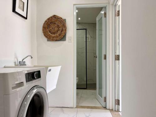 una lavadora en un baño con lavabo en Salitre Studio - Shared Pool Access, en Mameyal
