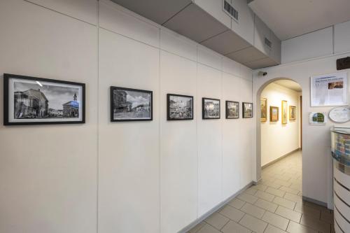 a hallway with pictures on the walls of a museum at Albergo Ristorante Brera in Inveruno