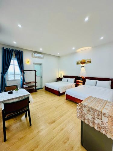 a hotel room with two beds and a table at New Sala Homestay in Hue
