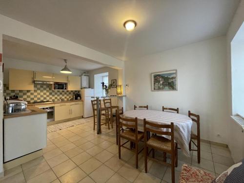 eine Küche und ein Esszimmer mit Tisch und Stühlen in der Unterkunft Burusenia in Hasparren